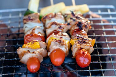 Izgara barbekü parçalı şişler, yeşil dolma biber, kırmızı domates ve et. Tayland 'da sokak pazarında satılıyor. Kapatın.