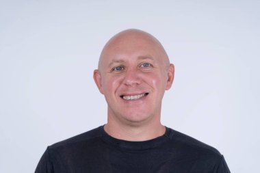 Kameraya bakan orta yaşlı, beyaz, kel bir adamın yakın çekimi. İnsanlar ve yaşam tarzı konsepti. İçerde orta yaşlı bir adamın portresi