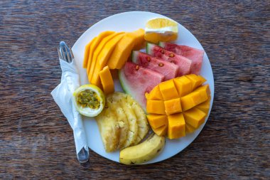 Kahvaltı tabağında tropik meyveler, yakın çekim. Taze karpuz, muz, tutku meyvesi, ananas, Jackfruit, mango, papaya, plaj restoranında yemek için portakal, ada Zanzibar, Tanzanya, Afrika