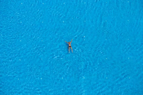 Woman swimming in a pool, top view, Summer travel and vacation concept