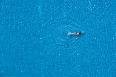 Havuzda yüzen bir kadın, manzaralı. Yaz seyahati ve tatil kavramı