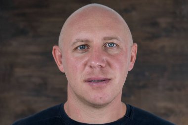 Kameraya bakan orta yaşlı, beyaz, kel bir adamın yakın çekimi. İnsanlar ve yaşam tarzı konsepti. İçerde orta yaşlı bir adamın portresi