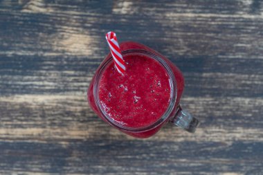 Beyaz masada cam bardakta taze organik kırmızı smoothie, yakın plan, üst manzara. Yaz meyvelerini tazeliyorum. Sağlıklı beslenme kavramı. Böğürtlen, ahududu ve çilekli smoothie