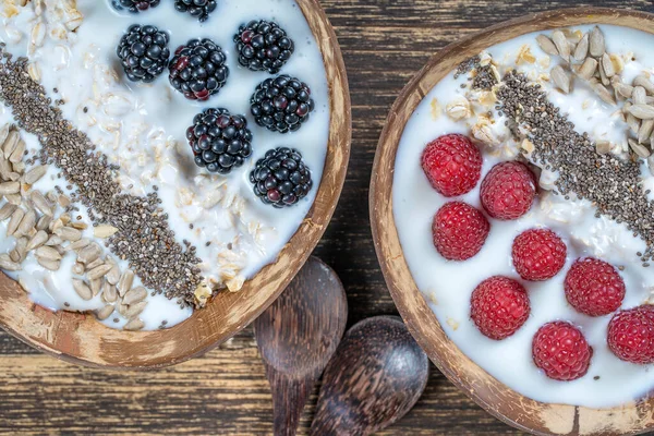 在椰子碗中加入黑莓 覆盆子 葵花籽和奇亚种子作为早餐 健康饮食的概念 超级食物 顶部视图 — 图库照片