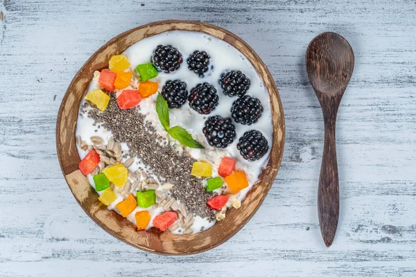 在椰子碗中加入黑莓 燕麦片 葵花籽和奇亚种子作为早餐 健康饮食的概念 超级食物 顶部视图 — 图库照片