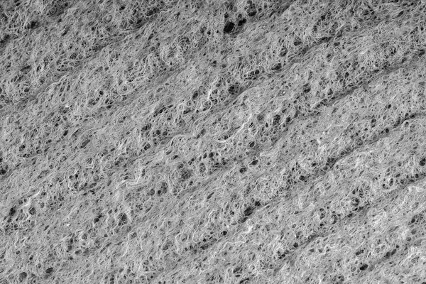 Household cleaning sponges close up. Sponge detail texture, sponge texture close up background. Cellulose sponge texture. Wire mesh on sponge surface background. Black and white