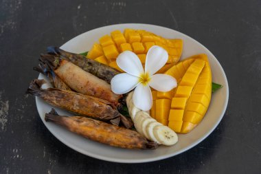 Tayland usulü tatlı, sarı mangolu ve palmiye yapraklı muzlu pilav. Sarı mango ve yapışkan pirinç Tayland 'ın popüler geleneksel yemeğidir. Kapat.