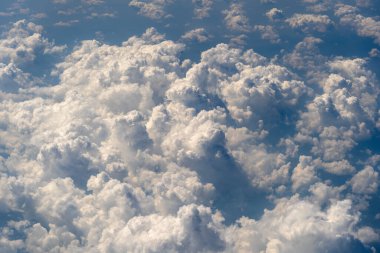 Beyaz bulutlar ve gökyüzü, uçak penceresinden bir manzara. Doğa arkaplanı