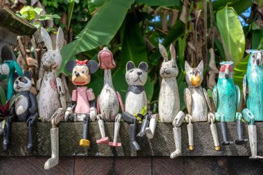 Endonezya 'daki Ubud, Bali adasındaki oyuncak dükkanının yanındaki taş çitin üzerinde eski ahşap oyuncaklar. Kapat.