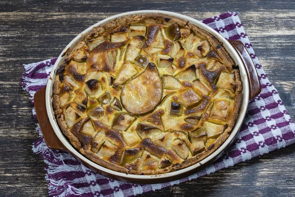 Homemade organic pear pie dessert ready to eat. Pear tart on the old wooden background, close up. Beautiful organic fresh fruit tart with gluten free crust