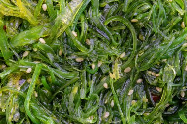 Arka planda susam tohumlu ve kırmızı biberli yosun salatası. Üst görünüm, kapat