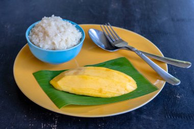 Tayland usulü tatlı, tabağında pilav olan mango. Sarı mango ve yapışkan pirinç Tayland 'ın popüler geleneksel tatlısıdır. Kapat.