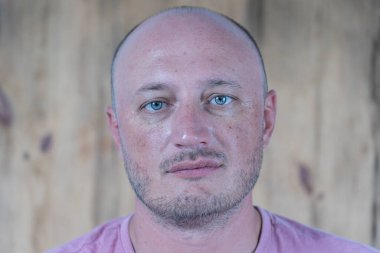 Kameraya bakan orta yaşlı, beyaz, kel bir adamın yakın çekimi. İnsanlar ve yaşam tarzı konsepti. İçerde orta yaşlı bir adamın portresi