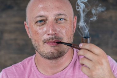 Pipo içen adam. İçerde orta yaşlı bir adamın portresi. Kötü alışkanlıklar, bağımlılık. Sağlıksız yaşam tarzı kavramı. Kapat.