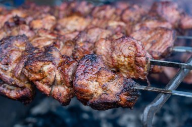 Barbeküde pişmiş et. Metal şişte pişen ızgara kebap. Barbekü taze et dilimleri. Geleneksel doğu yemeği, şiş kebap. Kömür ve alev ızgarası, sokak yemekleri, Ukrayna