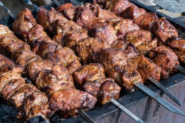 Barbeküde pişmiş et. Metal şişte pişen ızgara kebap. Barbekü taze et dilimleri. Geleneksel doğu yemeği, şiş kebap. Kömür ve alev ızgarası, sokak yemekleri, Ukrayna