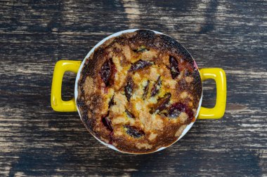 Ev yapımı organik erikli turta yenmeye hazır. Eski ahşap arka planda erik turtası, yakın plan.