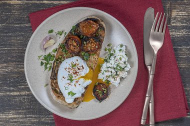 Kızarmış kırmızı domatesli haşlanmış yumurta, tabakta sarımsak ve süzme peynir, yakın çekim, üst manzara
