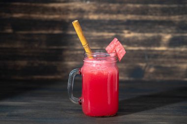 Ahşap arka plandaki cam kavanozda taze karpuz smoothie var, kapat. Sağlıklı gıda konsepti