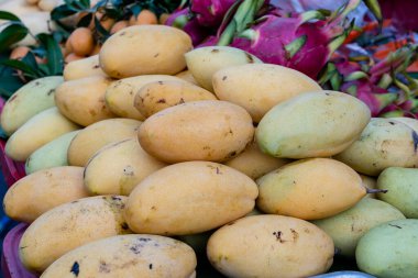 Mango, pitahaya ve Marian Plum Tayland 'daki yerel sokak pazarında satılıyor. Tropikal meyveler kapanıyor