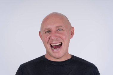 Kameraya bakan orta yaşlı, beyaz, kel bir adamın yakın çekimi. İnsanlar ve yaşam tarzı konsepti. İçerde orta yaşlı bir adamın portresi