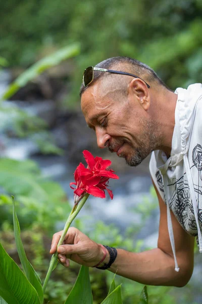 Hombre Está Oliendo Una Flor Roja Concepto Personas Estilo Vida —  Fotos de Stock