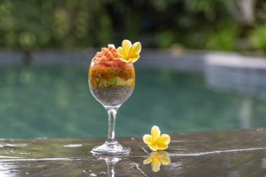 Papayalı Chia tohumu pudingi, tutku meyvesi, mango ve avokado kahvaltıda yüzme havuzu suyunun arka planında, yakın çekim. Sağlıklı beslenme, süper yemek kavramı.