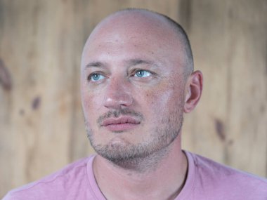 Orta yaşlı, beyaz, kel bir adamın yakın çekimi. İnsanlar ve yaşam tarzı konsepti. İçerde orta yaşlı bir adamın portresi