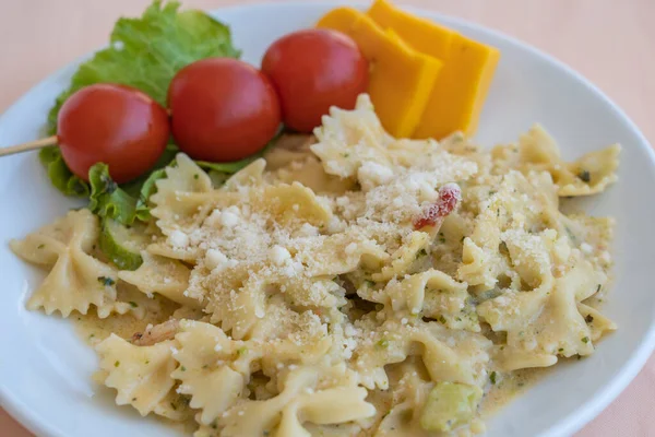 用樱桃 西红柿和奶酪包在白盘里的意大利面 — 图库照片
