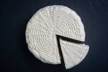 Siyah arka planda ev yapımı yumuşak beyaz peynir, yakın plan, üst manzara. Ev yapımı peynir. Sütten peynir.