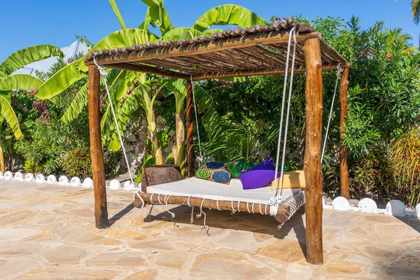 ビーチ 島Zanzibar タンザニア 東アフリカ 旅行と休暇のコンセプトの近くの熱帯の庭の天蓋の下にマットレスと枕を備えた木製のスイング — ストック写真