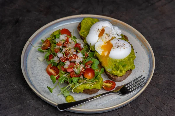 健康的早餐 配面包吐司和荷包蛋 配上绿色沙拉 红色西红柿和碎鳄梨 — 图库照片