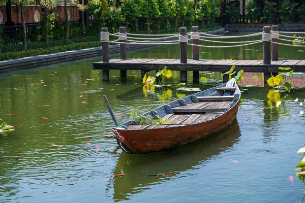 ベトナムのダナンのトロピカルガーデンの桟橋近くの池の上に木製のボート 旅と自然概念 — ストック写真