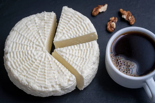 Homemade soft white cheese with white cup coffee and walnuts on black slate background, close up, top view. Home cheese making. Adyghe cheese from milk — Stock Image Homemade Soft White Cheese White Cup Coffee Walnuts Black Slate Royalty Free Stock Images