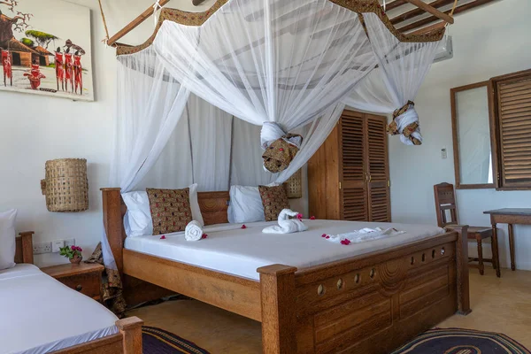 Lüks gösteriler için dekore edilmiş dört poster yataklı bir yazlık yatak odası. Doğu Afrika 'nın Zanzibar adasındaki tropikal villanın iç tasarımı