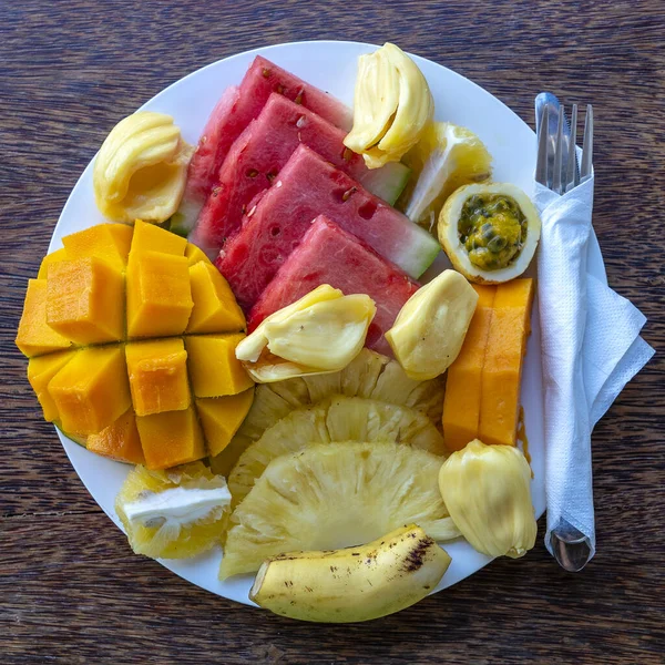 Kahvaltı tabağında tropik meyveler, yakın çekim. Taze karpuz, muz, tutku meyvesi, ananas, Jackfruit, mango, papaya, plaj restoranında yemek için portakal, ada Zanzibar, Tanzanya, Afrika