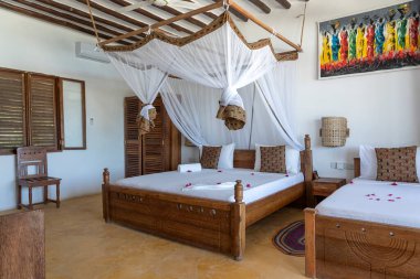 Lüks gösteriler için dekore edilmiş dört poster yataklı bir yazlık yatak odası. Doğu Afrika 'nın Zanzibar adasındaki tropikal villanın iç tasarımı