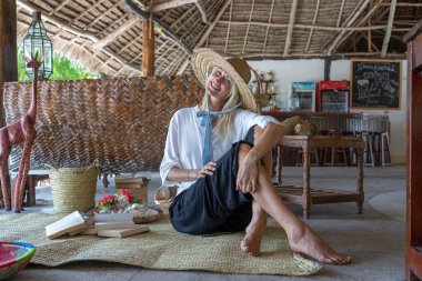 Tropikal bir plajda hasır şapkalı mutlu bir genç kadın, yakın plan portre, Zanzibar adası, Tanzanya, Doğu Afrika. Seyahat ve tatil kavramı