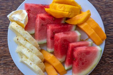 Kahvaltı tabağında tropik meyveler, yakın çekim, üst manzara. Taze karpuz, ananas, mango, papaya plaj restoranında yemek için portakal, ada Zanzibar, Tanzanya, Afrika
