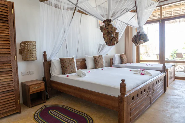 Lüks gösteriler için dekore edilmiş dört poster yataklı bir yazlık yatak odası. Doğu Afrika 'nın Zanzibar adasındaki tropikal villanın iç tasarımı
