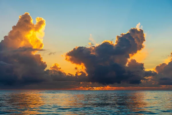 Beautiful sunrise over the Indian Ocean on the island of Zanzibar, Tanzania, east Africa. Travel and nature concept. Morning sky, clouds, sun and sea water