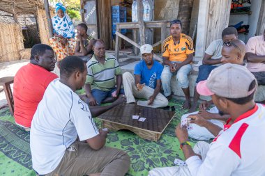 Zanzibar, Tanzanya - Aralık 02, 2019: Afrikalı erkekler Doğu Afrika 'daki Tanzanya' nın Zanzibar adasındaki tropik plaj yakınlarında kağıt oynuyorlar