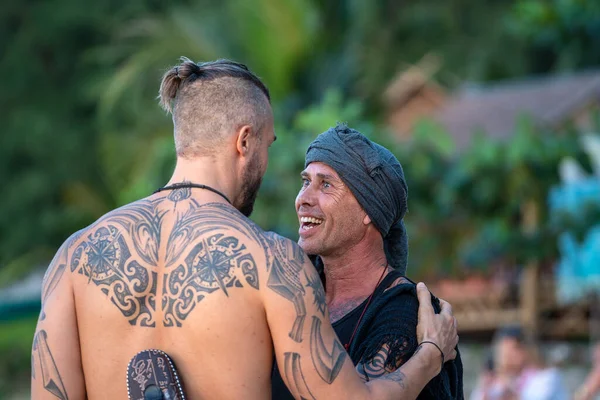 Koh Phangan, Tayland - Şubat 07, 2020: Koh Phangan, Tayland 'da günbatımında tropik bir plajda mutlu adamlar