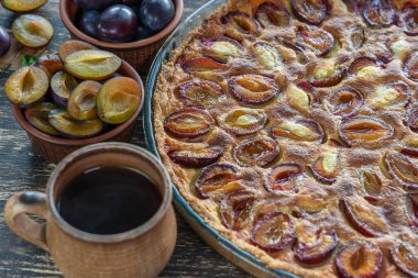 Ev yapımı organik erikli turta yenmeye hazır. Eski ahşap arka planda erik turtası ve fincan sıcak çay, kapatın.