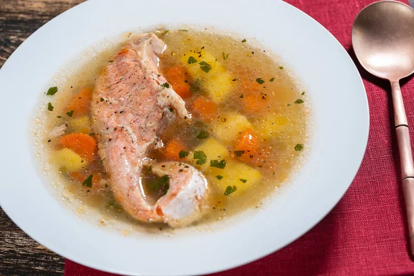 新鮮なサーモンの魚のスープ ニンジン ジャガイモ ハーブを白いプレートに入れ 閉じます おいしいディナーは魚のスープとサーモンで構成されています — ストック写真