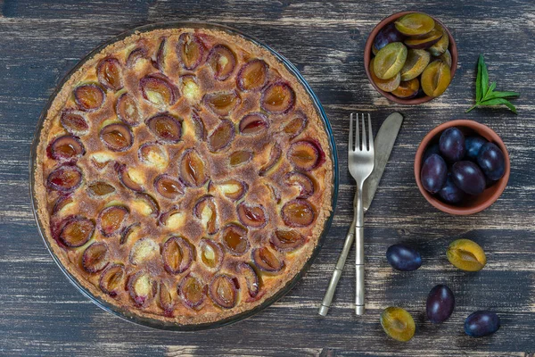 Ev yapımı organik erikli turta yenmeye hazır. Eski ahşap arka planda erik turtası, yakın plan.