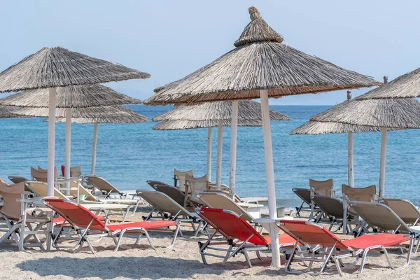 Güneş yatakları ve şemsiyeler sabah, deniz suyunun yanında. Deniz kıyısındaki lüks bir tatil köyünde. Güzel bir sabah deniz manzarası. Turistik yerler. Akdeniz plajı, yaz tatillerinde tatil yeri. Kos Adası, Yunanistan