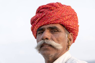 PUSHKAR, INDIA - 14 Kasım 2018: Hindistan 'ın kutsal şehri Pushkar, Rajasthan yakınlarındaki Pushkar Camel Mela sırasında çöldeki Hintli adam. Bu fuar dünyanın en büyük deve ticaret fuarı..