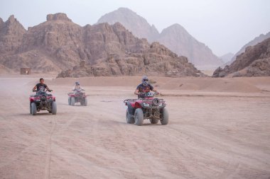 Sharm El Sheikh, Mısır - 19 Mayıs 2018: Sharm El Sheikh, Mısır yakınlarındaki çölde dört tekerlekli bisiklet safarisi. Güçlü hızlı off-road dört çekişli ATV 'ler, kumlu çölde motosikletler, yüksek dağlara karşı ralli