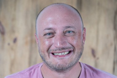 Kameraya bakan orta yaşlı, beyaz, kel bir adamın yakın çekimi. İnsanlar ve yaşam tarzı konsepti. İçerde orta yaşlı bir adamın portresi